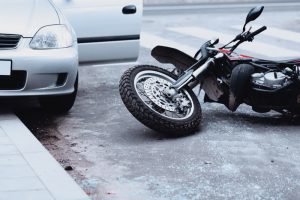 motorcycle accident beside parked car