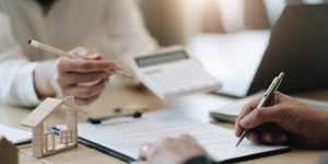 Two people at a table with a calculator determining fees.