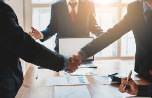 Two people shaking hands in front of a lawyer