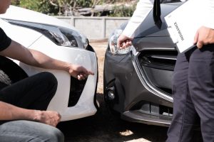 Person pointing to damage after a car accident for insurance.