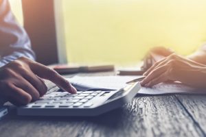 Person at a table calculating the fees for a settlement.